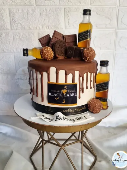 A chocolate lover's dream for a dad's 50th birthday. This drip cake is overloaded with chocolates, Ferrero Rocher, and Black Label miniatures.