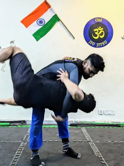 Grappling is the core of what we do. Here, I'm demonstrating a hip toss, a fundamental wrestling technique that is crucial for controlling an opponent in MMA and self-defense situations. Understanding how to transition from standing to the ground is a game changer.