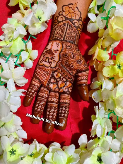 Another beautiful Karwachauth mehendi design, surrounded by flowers.