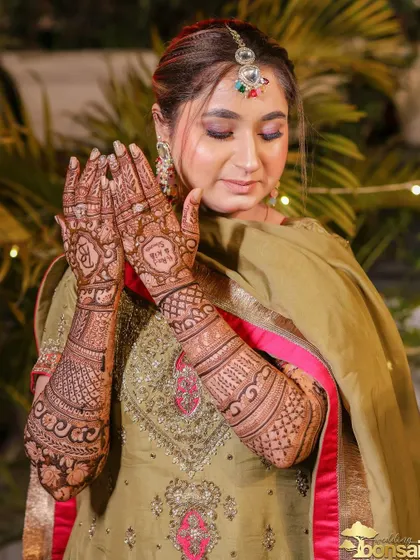 The bride proudly displaying her detailed henna, a key part of the pre-wedding rituals.