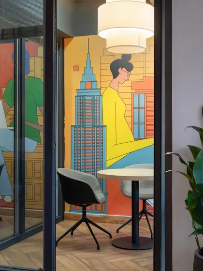 A peek into one of the smaller meeting rooms, where a large, colorful mural of the New York skyline adds a vibrant, urban energy to the space.