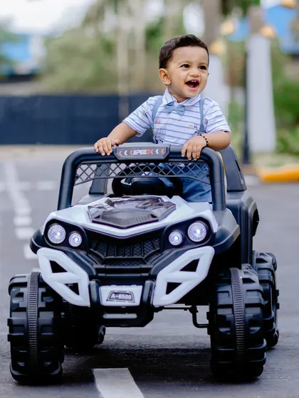 A happy little driver celebrating his birthday in style. Using fun props like this toy jeep makes for dynamic and playful photos.