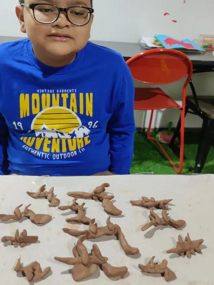 The pride on this young creator's face says it all. After a fun session focused on what he loves, he created an entire army of clay dinosaurs. My children's pottery classes are all about sparking imagination and celebrating their unique interests.