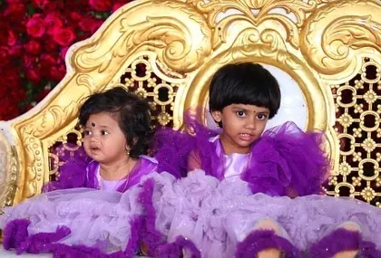 A close-up of the twinning sisters on a beautiful golden chair. Their outfits are designed to be comfortable and photogenic.