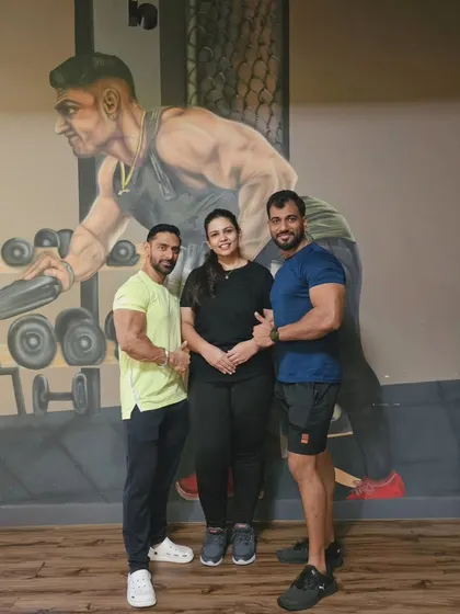 Standing proudly with my client and her trainer. Her success is a result of her dedication and our expert guidance.