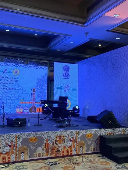 A side view of the stage for the BMRCL event, showing the keyboard and musical instruments ready for the performance. We ensure the stage layout is practical for artists and technically sound.