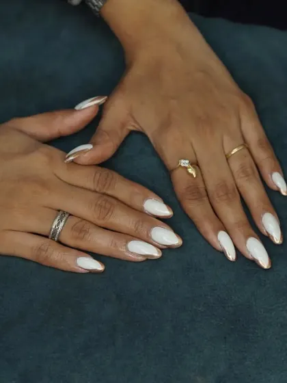 A full view of the elegant white and gold chrome drip nails.