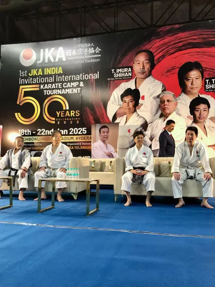 Senior JKA Shihans from Japan seated on stage during an international camp. My students have the rare privilege of learning directly from these masters, who carry the lineage of Shotokan karate.