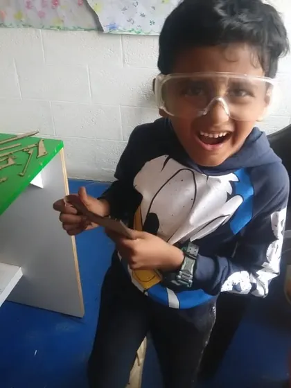 The excitement is building! A student in safety goggles is thrilled to be starting a new project.