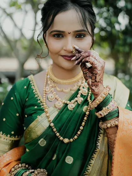 A close-up of the bride's happy face, with her mehendi-adorned hand adding to the picture.