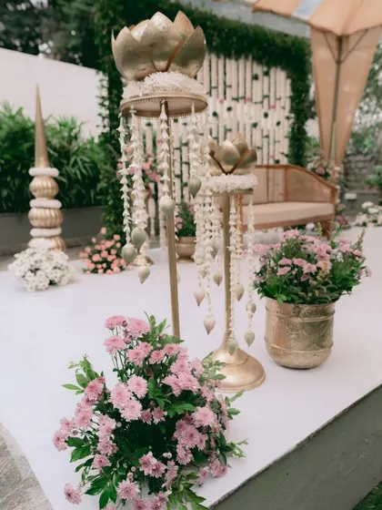 Details of the decor for an intimate engagement. I used brass lotus-themed props with hanging jasmine strings and pots of fresh pink flowers to add a touch of traditional elegance to the modern setup.