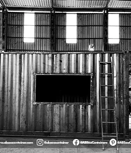 A customized structure takes shape in our workshop. This image shows a container with cutouts for large windows and doors, ready for the next stage of fabrication.