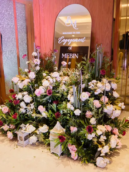 The entrance to the engagement party was marked by a beautiful mirror welcome sign, surrounded by a lush arrangement of pink and white flowers and lanterns, creating a warm and inviting first impression.