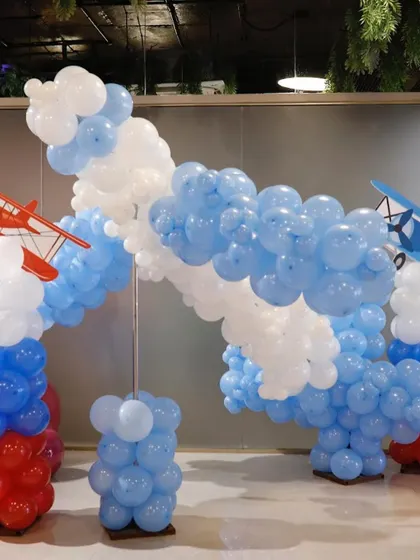 A "Time Flies" airplane-themed party entrance, featuring clouds made of balloons and vintage airplane models. We create immersive entrances that set the tone for the entire event.