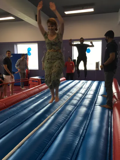 Pure joy! A mom leaps into the air on the Air Track, showing that our parties are fun for the whole family.