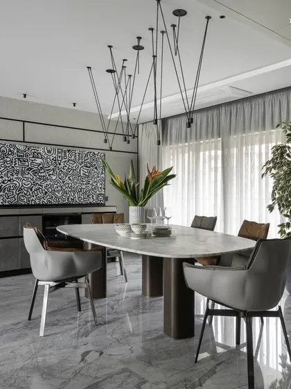 This bachelor pad in Cuffe Parade features a combined living and dining area with breathtaking sea views. A compact marble dining table sits perfectly poised for informal gatherings, complemented by a dramatic black and white doodle art piece by Mr. Doodle.