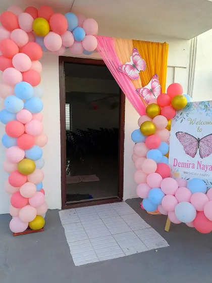 A colorful butterfly-themed entrance arch with a personalized welcome board.