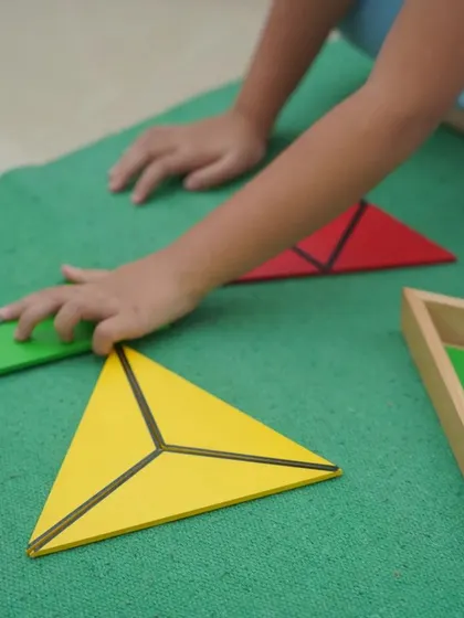 The constructive triangles are a sensorial material that allows children to explore geometric shapes. By combining different triangles, they can form squares, rectangles, and other polygons, discovering geometric relationships on their own.