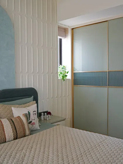 A view of the master bedroom's wardrobe, finished in a striking combination of back-painted glass and fluted glass, bringing together opulence and functionality.