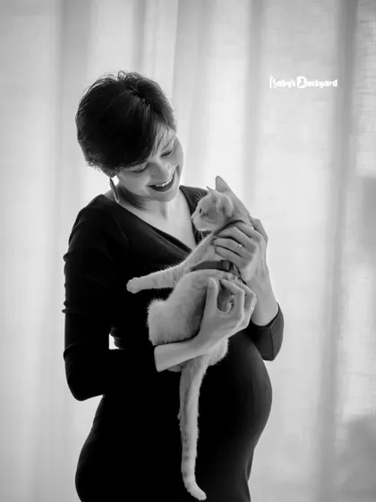 A sweet cuddle with the first baby of the house. This black and white photo captures the gentle love between an expecting mother and her cat.