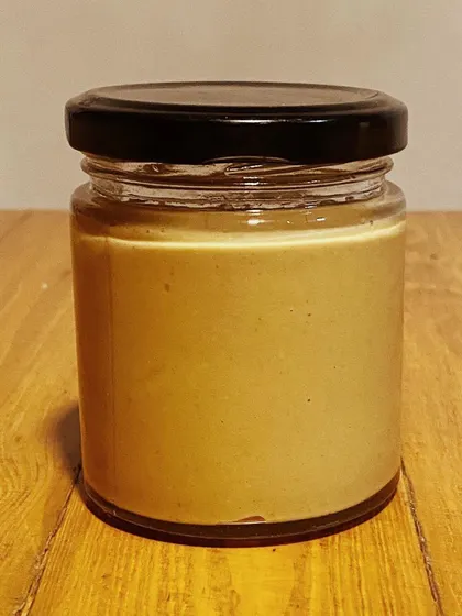 A jar of our pure, creamy peanut butter. It contains nothing but peanuts, making it a perfect, protein-packed snack for your dog.