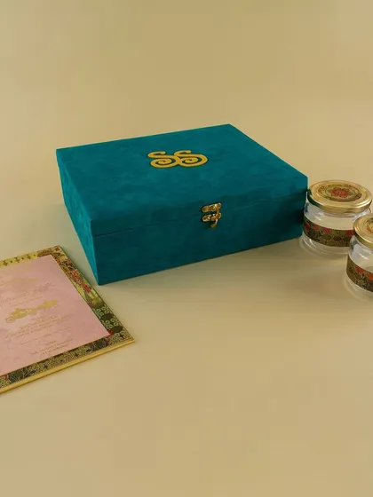 A minimalist yet luxurious teal velvet box with a custom gold monogram. This design is perfect for couples who want a clean, modern look for their boxed invitation.