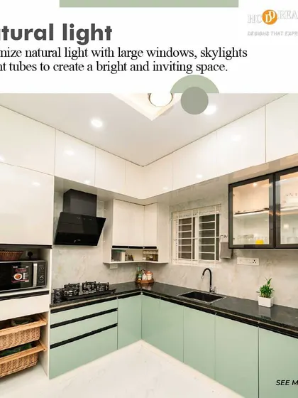 Natural light is essential in a kitchen. This design maximizes it with a large window, complemented by light green and white cabinets that create a bright, airy, and inviting atmosphere.