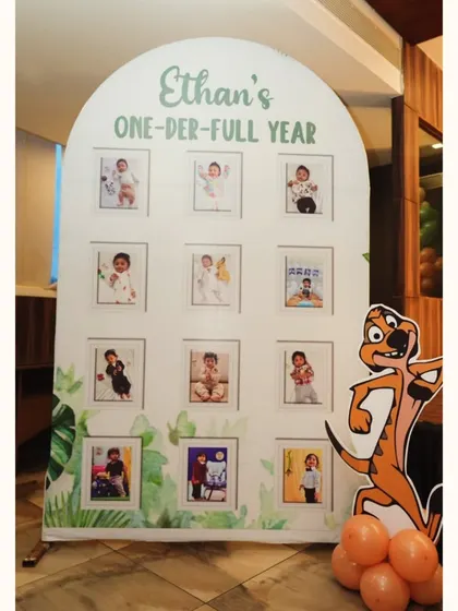 This personalized "ONE-der-full YEAR" photo board was a highlight of Ethan's Lion King party. It showcases photos from his first year, creating a heartwarming and personal touch for guests to enjoy.