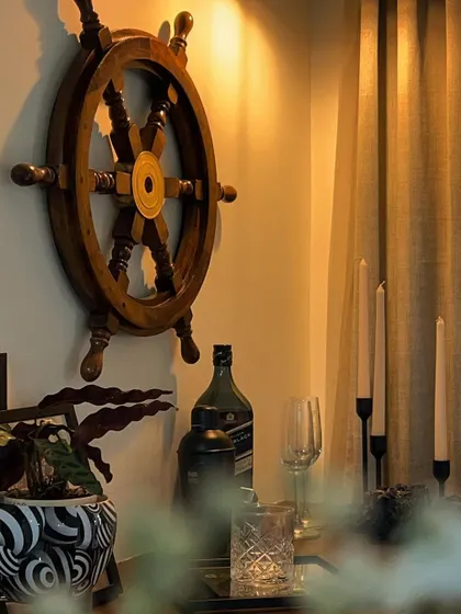 We love adding personal touches that reflect our clients' passions. This nautical-themed bar corner, complete with a ship's wheel, is a perfect example of personalized decor.