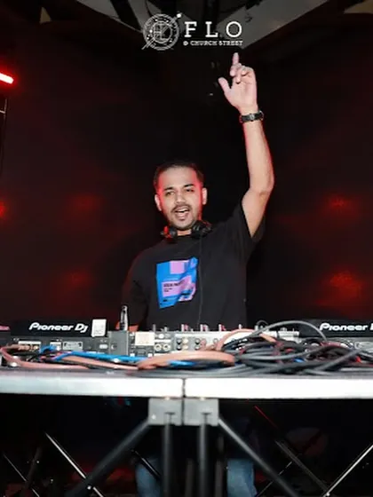 A classic DJ pose at Flo Church Street, hand in the air, signaling to the crowd.