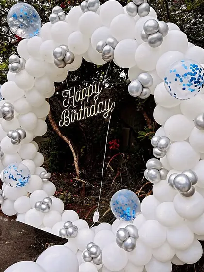 A close-up of the white and silver balloon ring for an outdoor adult birthday party.