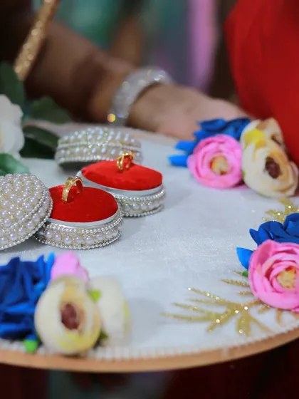 A beautifully arranged engagement ring tray, with the rings presented in decorative red boxes.