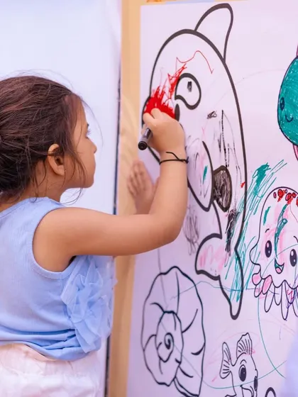 A young guest adding her artistic touch to the communal coloring wall.
