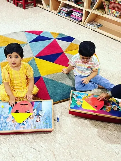Even our youngest members get involved in the Dussehra crafts. Here, a little one is putting the finishing touches on her Ravan mask with some help.