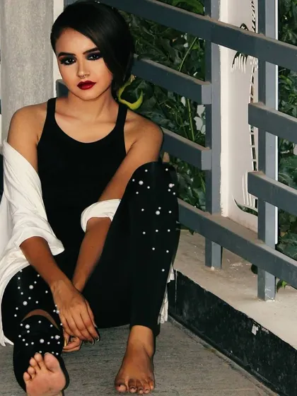 This image showcases an edgy, modern look with a dark smokey eye and a deep red lip. The styling with the all black outfit makes this a great example of makeup for a contemporary party or photoshoot.