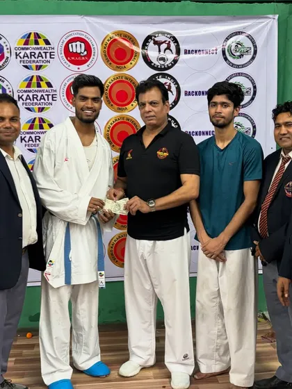 Harshit Pandey receiving a cash prize from Hanshi Bharat Sharma ji for winning the Open Challenge at the Victor Cup.