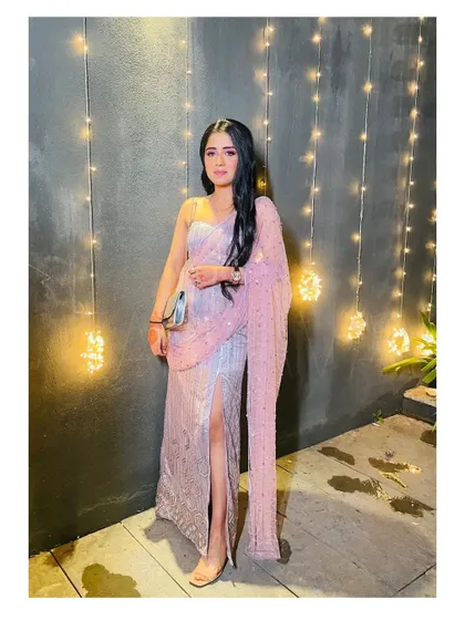 The embellished slit skirt set seen against a backdrop of fairy lights, highlighting the sparkle of the fabric and the modern cut of the outfit.