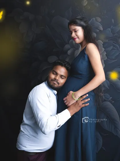 A classic and heartfelt pose where the father-to-be listens to the baby bump against a dark floral backdrop. These moments are precious to capture.
