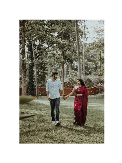 A romantic walk through a park, with the couple holding hands.