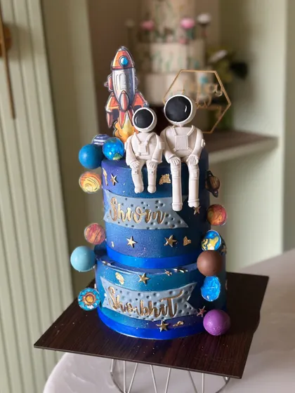 From planets to rockets, this galaxy cake has it all. This two-tiered space-themed cake features handcrafted astronauts and colorful planets to take your celebration to the stars.