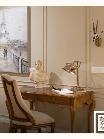 Creating a classic study station starts with timeless pieces. Here, a classical bust and a vintage-style desk lamp are paired with a Parisian art print to evoke an atmosphere of intellectual curiosity and vintage appeal.