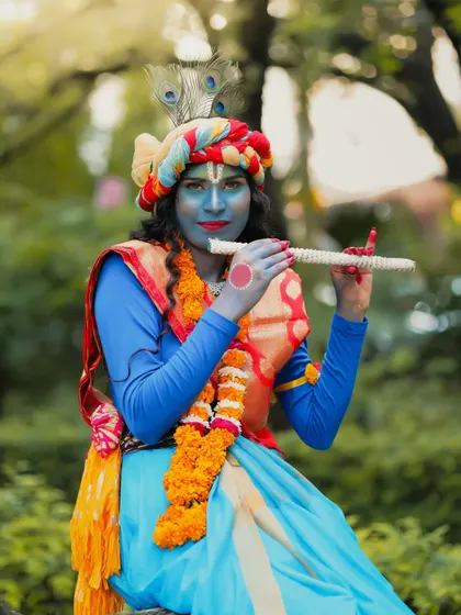 A solo portrait of the student as Krishna, showcasing the detailed makeup, including the peacock feather and flute.