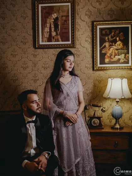 A vintage-themed couple portrait, using classic furniture and warm lighting to create a timeless and moody photograph.