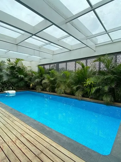 A private indoor swimming pool with a translucent roof that floods the space with diffused natural light, creating a bright and tranquil oasis.