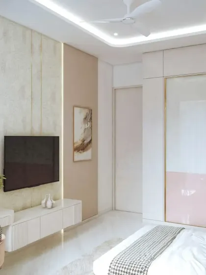 This is the TV and wardrobe view of the blush-toned bedroom. The sliding wardrobe doors feature a two-tone design with gold accents, matching the room's modern and luxurious theme.