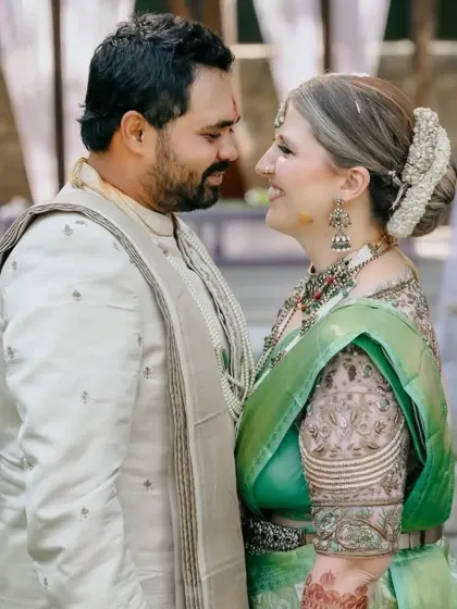 A sweet moment between the bride and groom, with a glimpse of the rich henna stain on her arm.