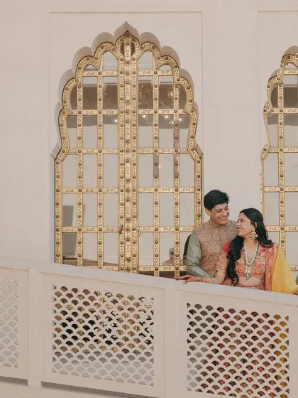A lovely moment shared on a balcony with ornate golden windows in the background, adding a touch of royalty to the portrait.