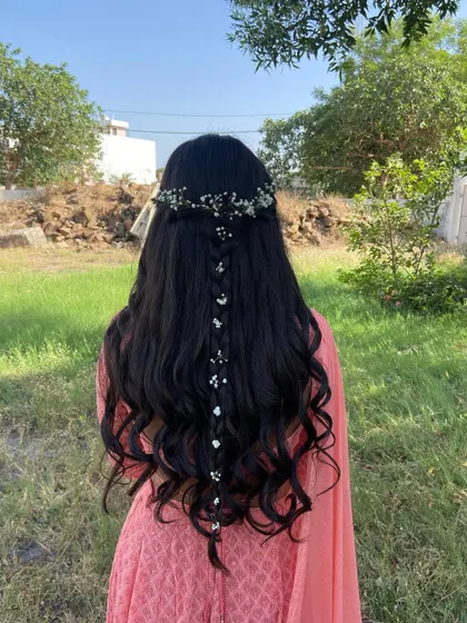 A beautiful open hairstyle with a delicate center braid and baby's breath, perfect for a daytime event.