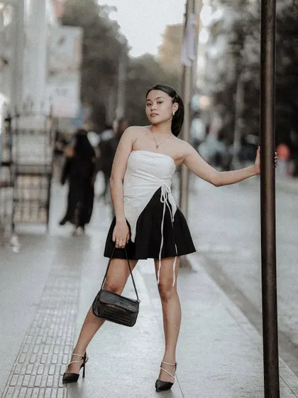 A full-length street style portrait, using a pole as a prop to create a dynamic pose. I often use elements of the environment to make shots more interesting.