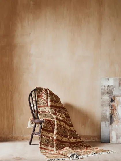 A simple, elegant still life focusing on the texture and pattern of a rug. The monochromatic color palette and soft lighting create a calm, artistic mood for this home fashion brand.